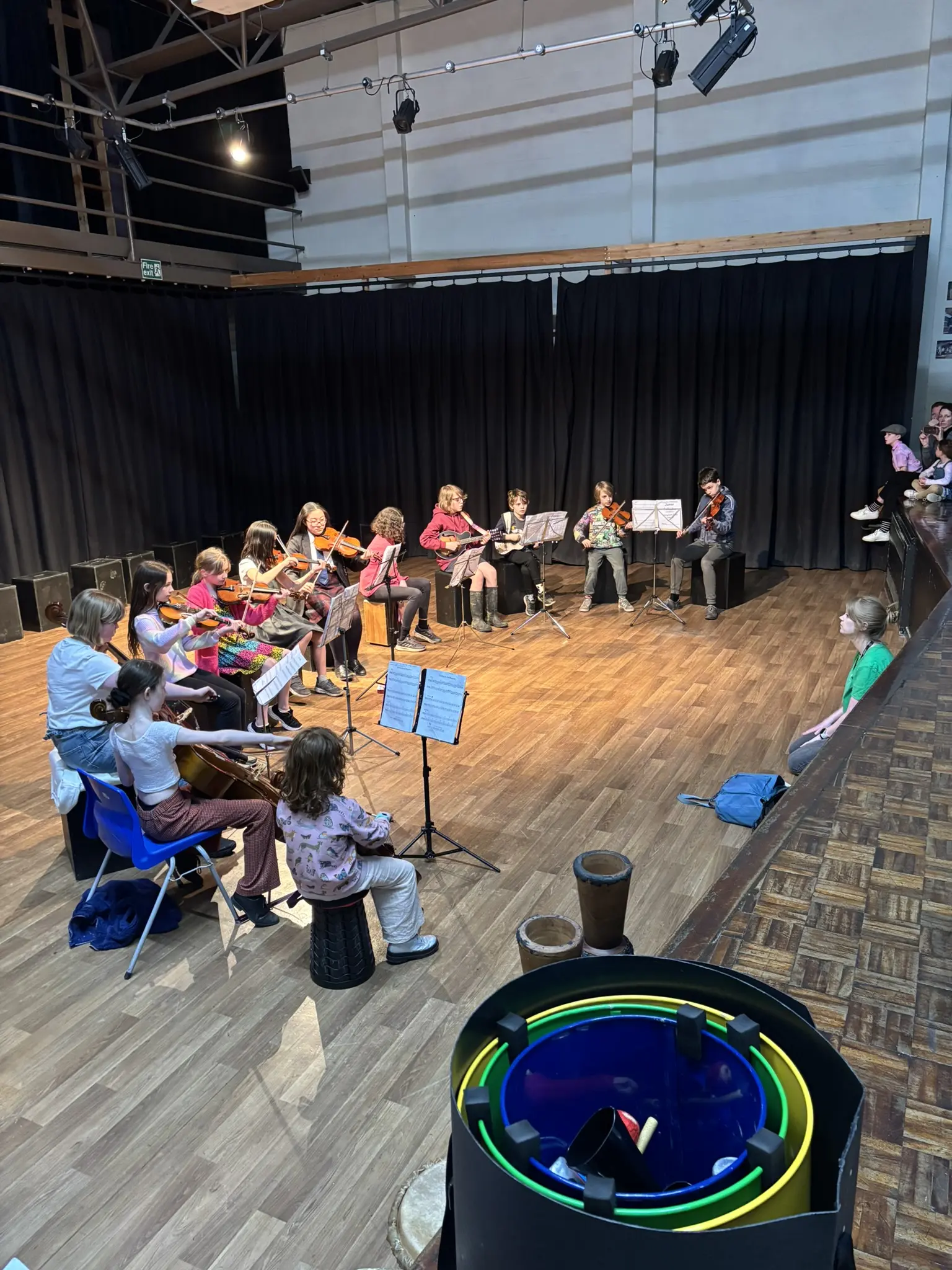 A young ensemble performing together on stage