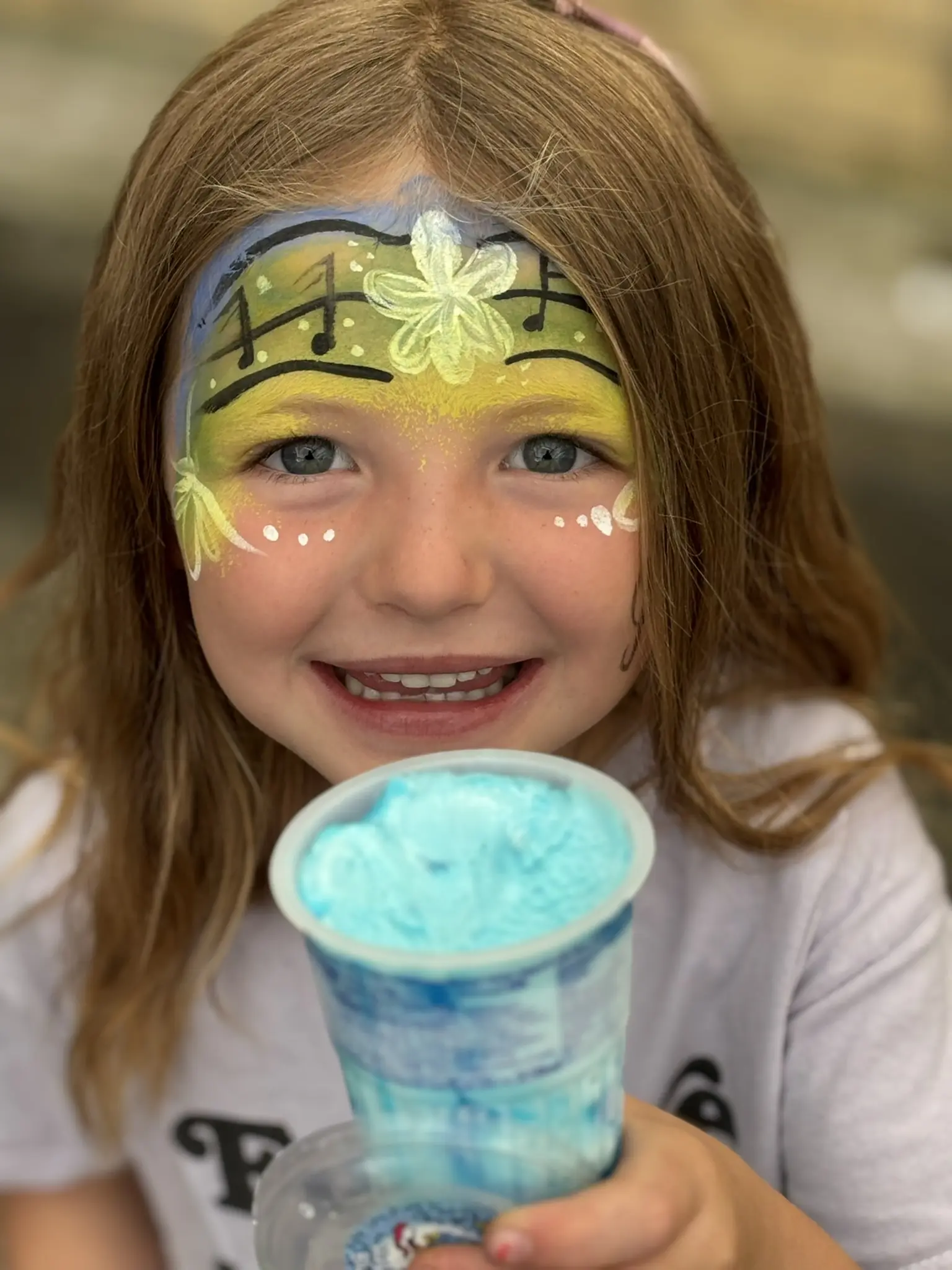 A young musician with musical notes painted across her face